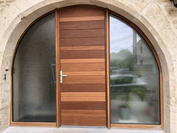 Porte d'entrée cintrée en bois massif et fixes latéraux vitrés